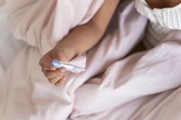 Close up of female hand that holding thermometer