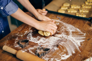 Mother and daughter cooking holiday cookies in winter season at home