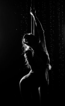 Beautiful wet athletic busty elegant blonde girl performs artistic elements of an exotic dance on the rain. Health, lifestyle, sports, black white monochrome design. Copy space.