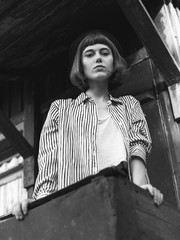 Beautiful young woman standing on the porch. Black and white