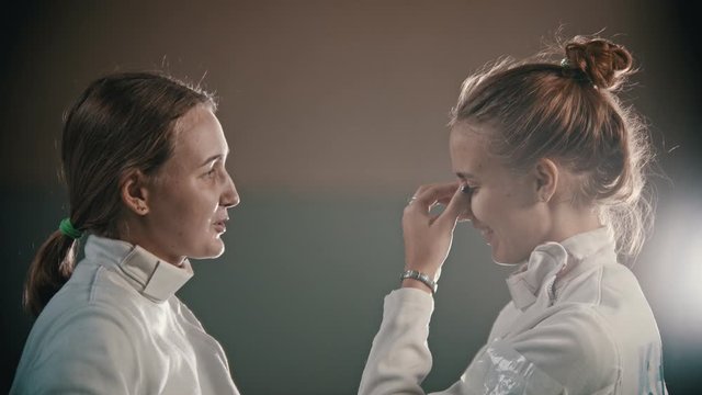 Two young women fencers talking to each other