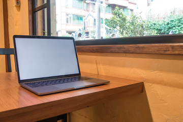 Conceptual workspace, Laptop computer with blank white screen on table, blurred background. use in...