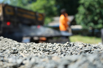 Naklejka premium Workers are mixing hot stone caused by burning. Mixed with high temperature asphalt In order to repair the road (blurred images)