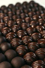 Round chocolates candy. Dark background, luxury dessert, dark chocolate, handmade. Vertical photo.
