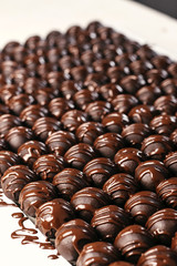 Round chocolates candy. Dark background, luxury dessert, dark chocolate, handmade. Vertical photo.