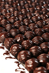 Round chocolates candy. Dark background, luxury dessert, dark chocolate, handmade. Vertical photo.
