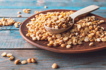 Dry yellow peas in a bowl on old boards. Chipped yellow peas are used for cooking.