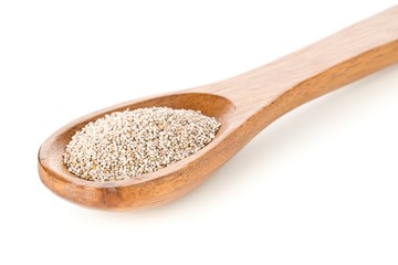 White whole, organic chia seeds heap in brown wooden spoon over white background
