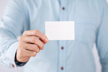 Businessman showing a blank business card on white background