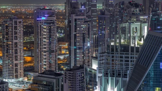 Dubai Marina illuminated skyscrapers and jumeirah lake towers view from the top aerial night timelapse in the United Arab Emirates. Traffic on a road
