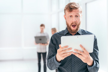 surprised businessman reading SMS on his tablet