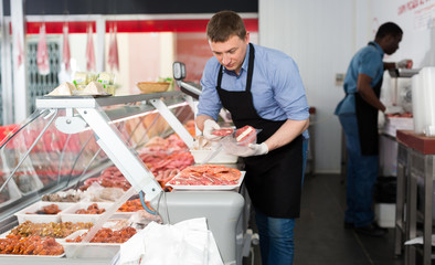 Fototapeta na wymiar Two butchers arranging meat display
