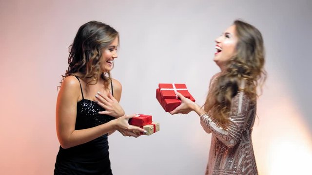 Young women giving each other presents, kissing and hugging.