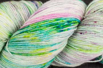 skein of multicolored white wool with green and pink
