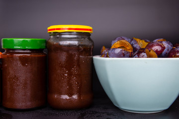 Jars and a bowl full of plum jam