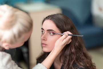 makeup artist doing makeup for a young woman client