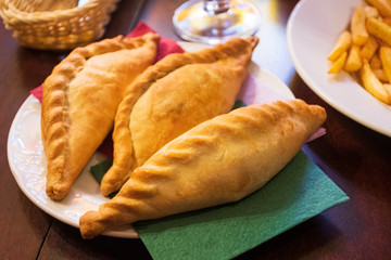 Kibinai, traditional Lithuanian food, pastries filled with various meat, onion and pepper, popular with Karaite ethnic minority in Trakai, Lithuania, tasty snack with french fries 