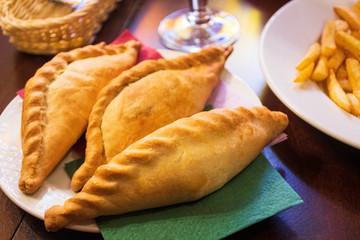 Kibinai, traditional Lithuanian food, pastries filled with various meat, onion and pepper, popular with Karaite ethnic minority in Trakai, Lithuania, tasty snack with french fries 