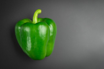 Green pepper on a black background. Fresh bright colorful peppers on a black background