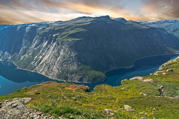 Mountain lake landscape, Odda, Norway. Ringedalsvatnet lake panorama with sunset sky, Way to Trolltunga rock.