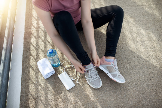 Picture of sport woman tying shoes. Fitness women training and doing workout outdoors in city.