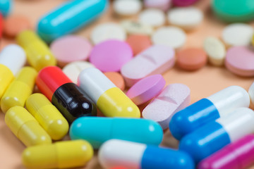 Colored tablets and pills on a orange background