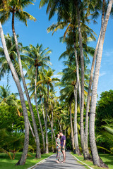 Young couple in love walking on exotic island, by the coconut palms. Happy couple enjoying in walk