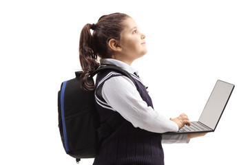 Schoolgirl in a uniform using a laptop computer and looking up