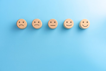 Wooden blocks with the happy face smile face symbol on blue background, evaluation, Increase...