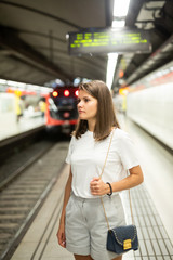 Woman waiting subway car on platform