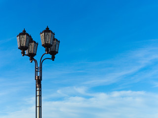 Fototapeta na wymiar Vintage style city lantern in the street against a blue sky with clouds