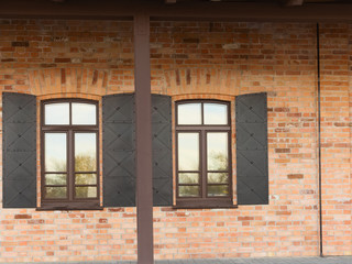 Windows of an old brick-built building with metal shutters