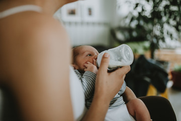 Closeup portrait of 1 month old baby eating milk from bottle
