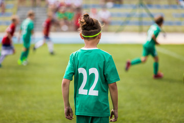 Obraz premium One caucasian soccer player playing game with friends. Back of kid football player waiting for ball pass. Football sports tournament on school pitch