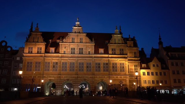 Gdansk, Poland - September 2019: Green Gate (Brama Zielona). View of the evening street of the old city. Tourists walk around the night city. Evening illumination.