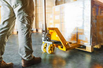 Workers using Hand Pallet Jack Unloading Packaging Boxes on Pallet. Cargo Supply Chain. Shipment Boxes. Storage Warehouse Shipping Transport Logistics.