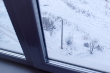 View from the window of high-rise buildings in the yard on the street in winter