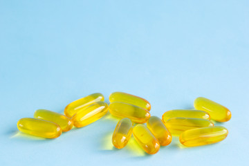 Capsules omega3, pills fish oil, cod-liver fat or flaxseed linseed oil on light blue background
