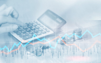 Double exposure of city and rows of coins with stock and financial graph. Hand counts on a calculator.