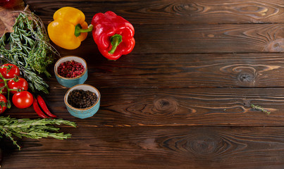 bell peppers, rosemary, cherry tomatoes and other ingredients for cooking on wooden rustic background top view