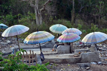 Umbrellas over graves and coffins at Nusa Lembongan cemetery, Indonesia