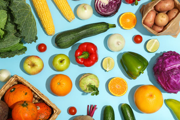 Different vegetables and fruits on blue background, top view