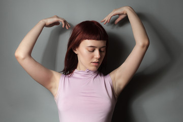 Fototapeta premium Young woman in pink shirt posing in studio