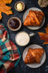 cappuccino coffee with croissant on the table, autumn breakfast concept, top view
