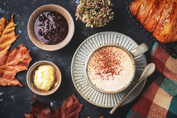 cappuccino coffee with croissant on the table, autumn breakfast concept, top view