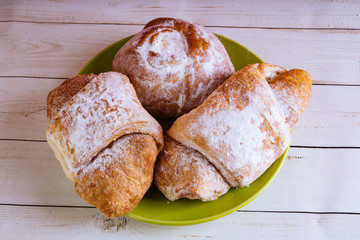 Fresh sweet pastries on white wooden background