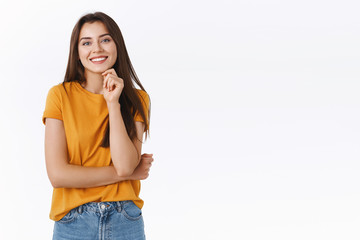 Enthusiastic, good-looking successful lucky girl in yellow t-shirt, hold chin up and smiling...