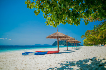 Umbrella wooden and kayak on tropical beach.