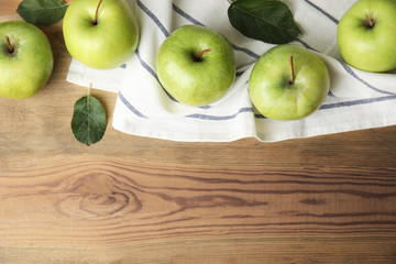 Flat lay composition of fresh ripe green apples on wooden background, space for text