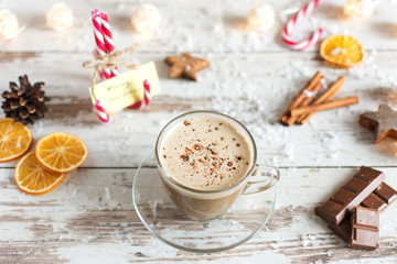 Hot cup of cappuccino or hot milk chocolate with dried orange fruit and cinnamon.